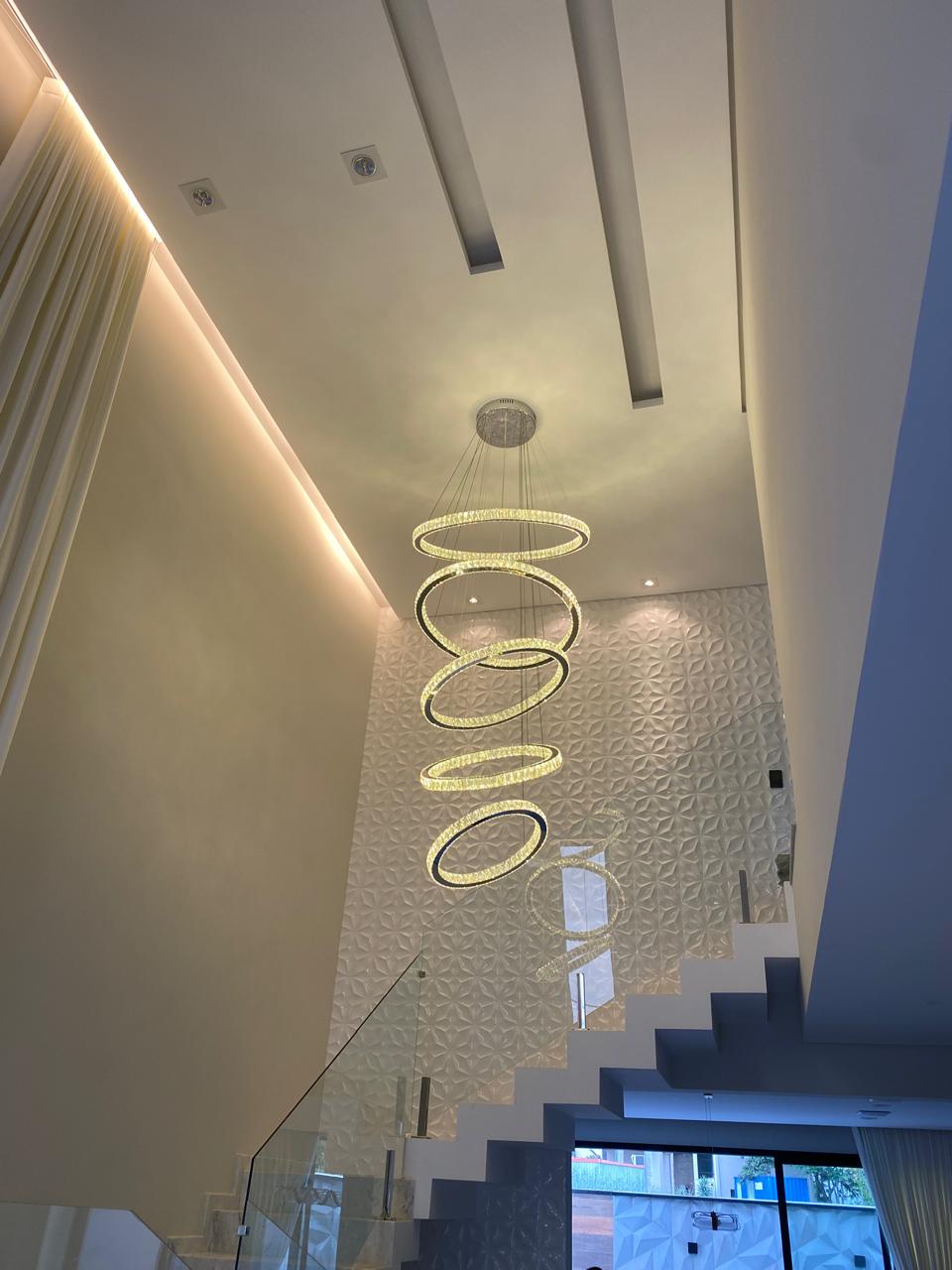 Luminária de anéis em LED e cristal sobre escada