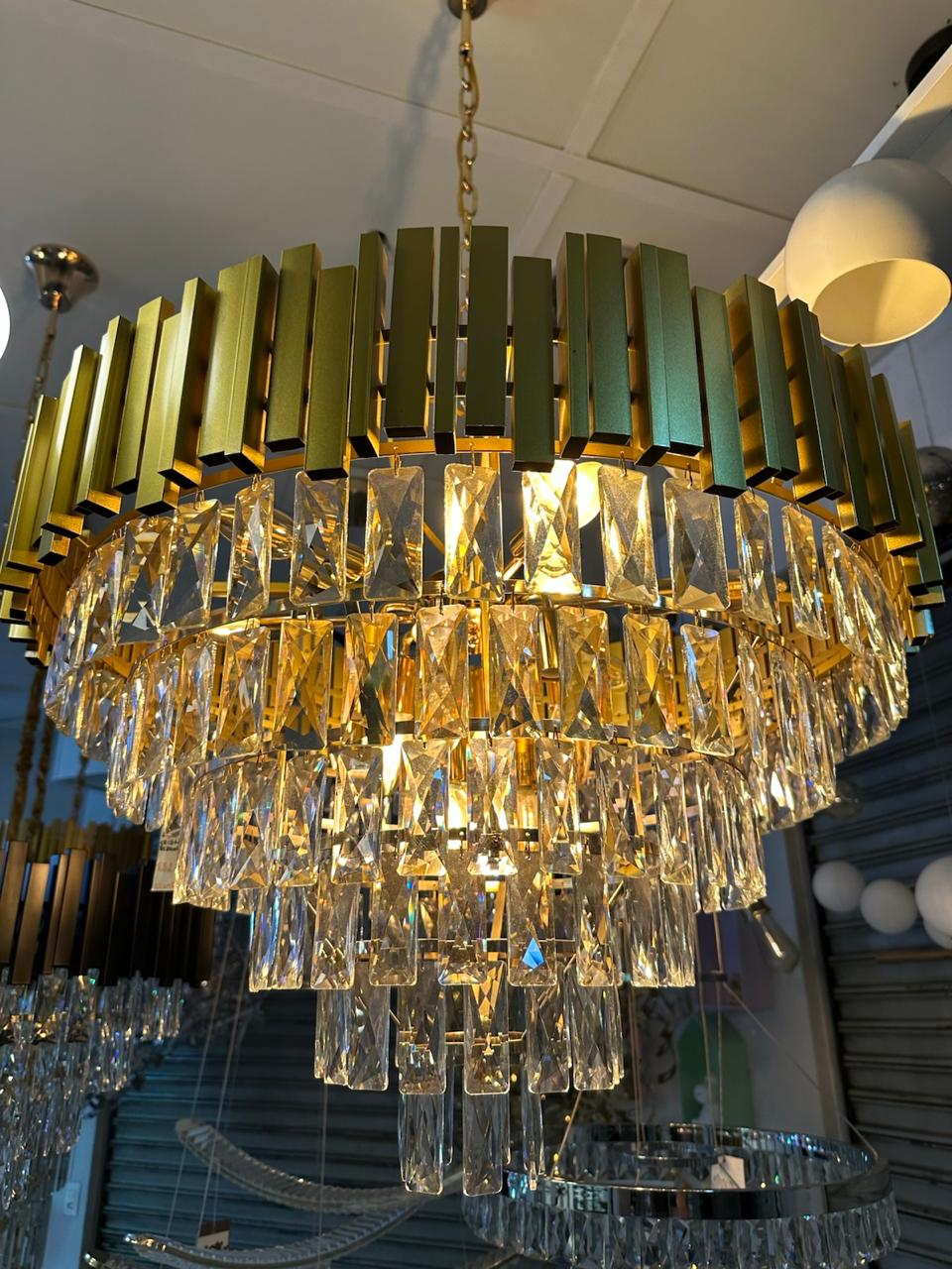 Lustre de cristal com acabamento dourado em exposição na loja